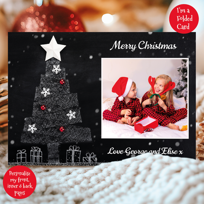 a christmas card with a picture of two children sitting in front of a christmas tree