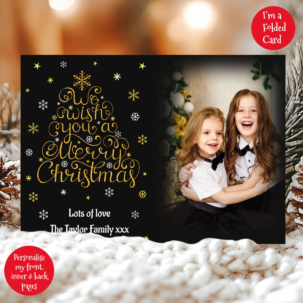 a christmas card with a picture of two girls in front of a christmas tree