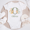 Personalised baby jungle safari animal vest in olive green, featuring an initial and name' design with adorable illustrations of a giraffe, lion, fox, elephant and zebra on a white bodysuit. Perfect for newborns to 12 months.